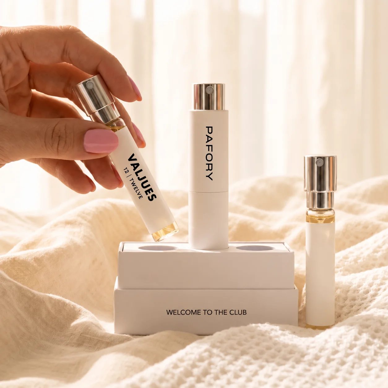 Hand holding the 8 ml Valjues 12 | TWELVE scent, next to the white PAFORY case on the Member Box